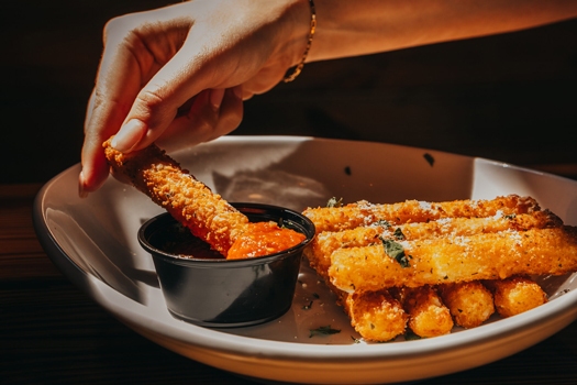 mozz stick getting dipped at miller's ale house